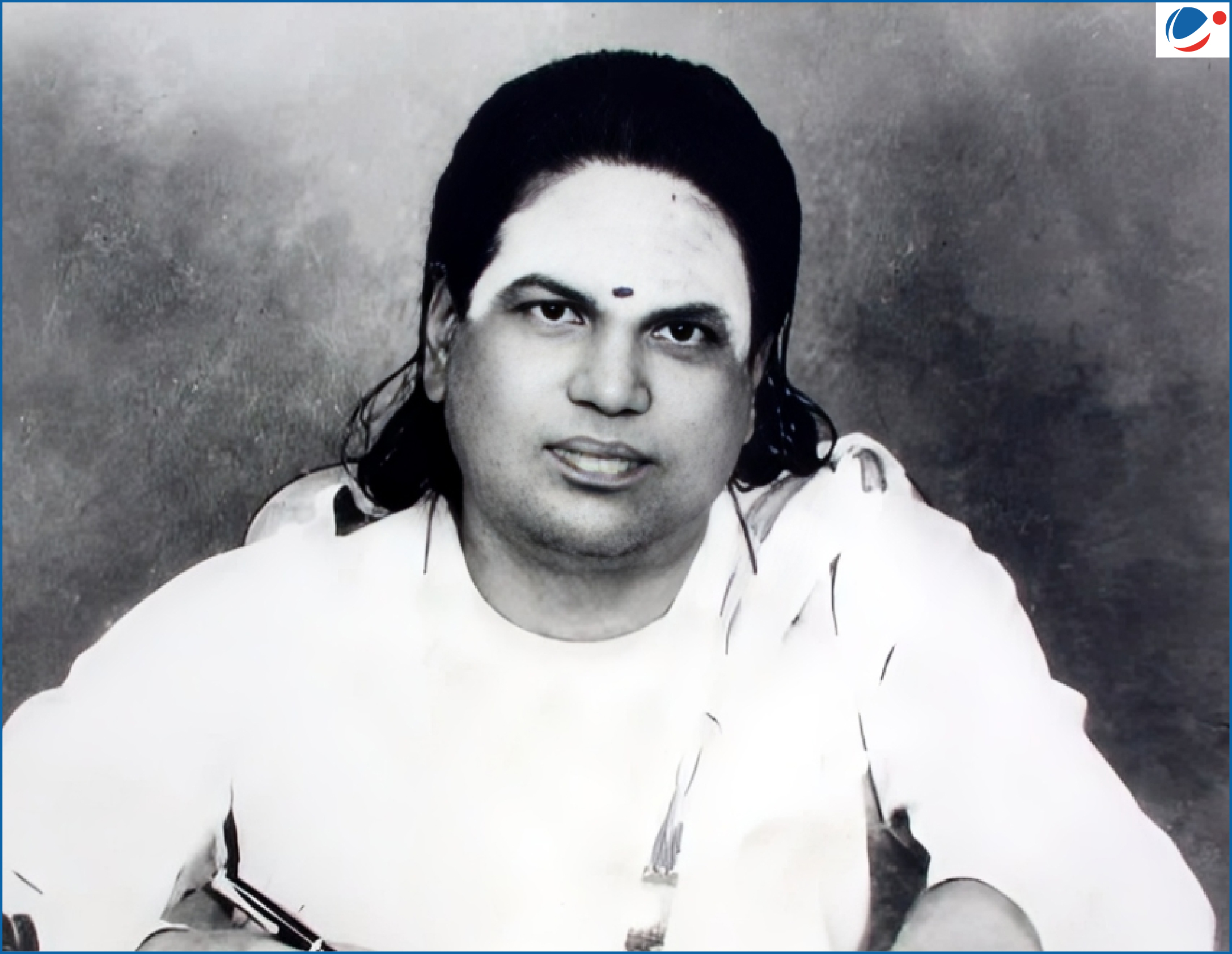 Portrait of Pasumpon Muthuramalinga Thevar, dressed in traditional Indian attire, seated and holding a pen against a plain background.